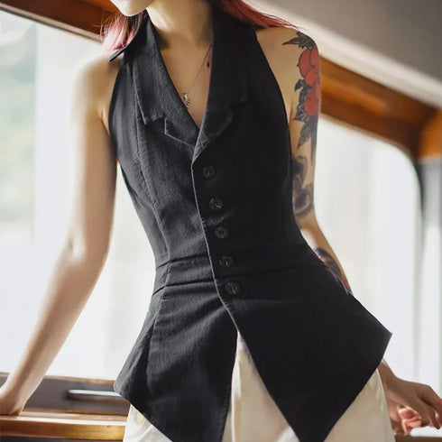 Person wearing a black vest indoors with a blurred background